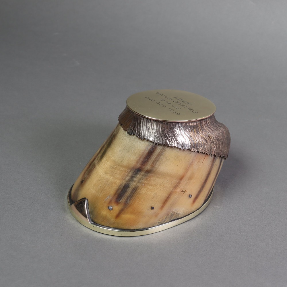 A preserved horse hoof mounted with an engraved brass top plate detailing military service dates and fitted with a polished brass rim around the base. View VII