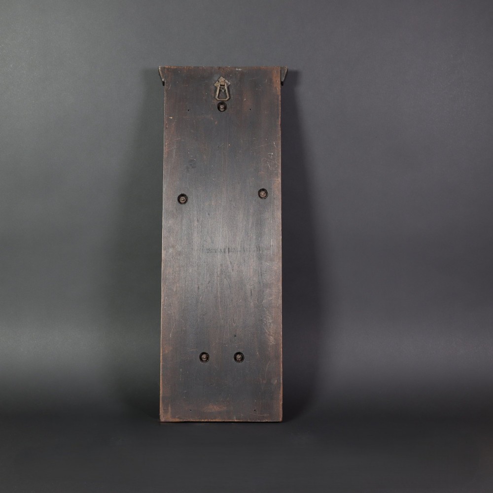 A patinated copper wall sconce with stylized Art Nouveau repousse details mounted on a dark rectangular wooden backboard. View VI