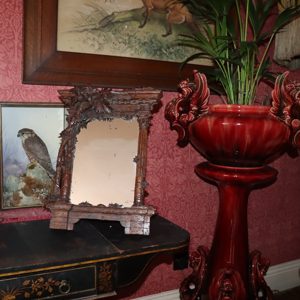 A late nineteenth-century Black Forest carved walnut table mirror featuring ornate architectural columns and botanical leaf carvings around the central rectangular mirror glass. View II