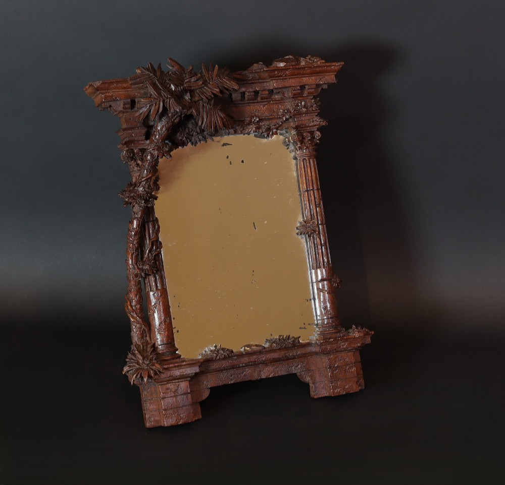 A late nineteenth-century Black Forest carved walnut table mirror featuring ornate architectural columns and botanical leaf carvings around the central rectangular mirror glass. View III