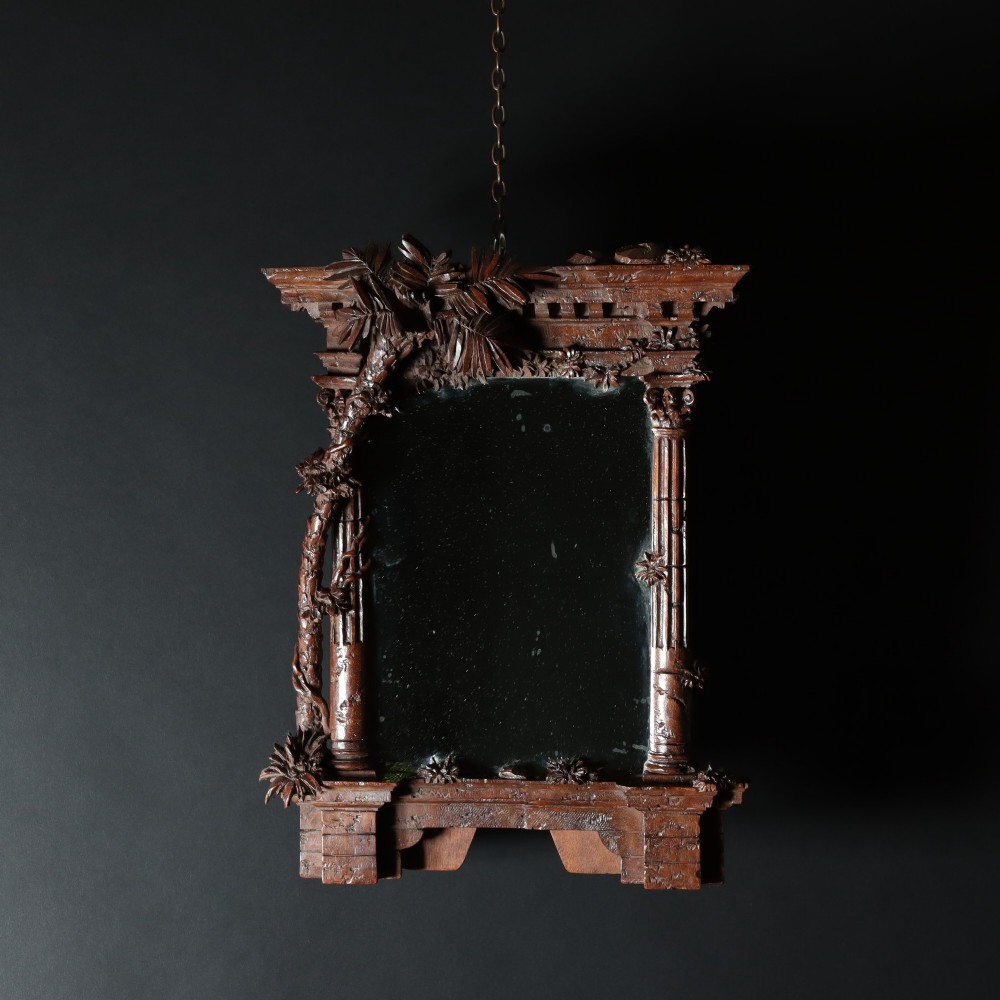 A late nineteenth-century Black Forest carved walnut table mirror featuring ornate architectural columns and botanical leaf carvings around the central rectangular mirror glass. View VI