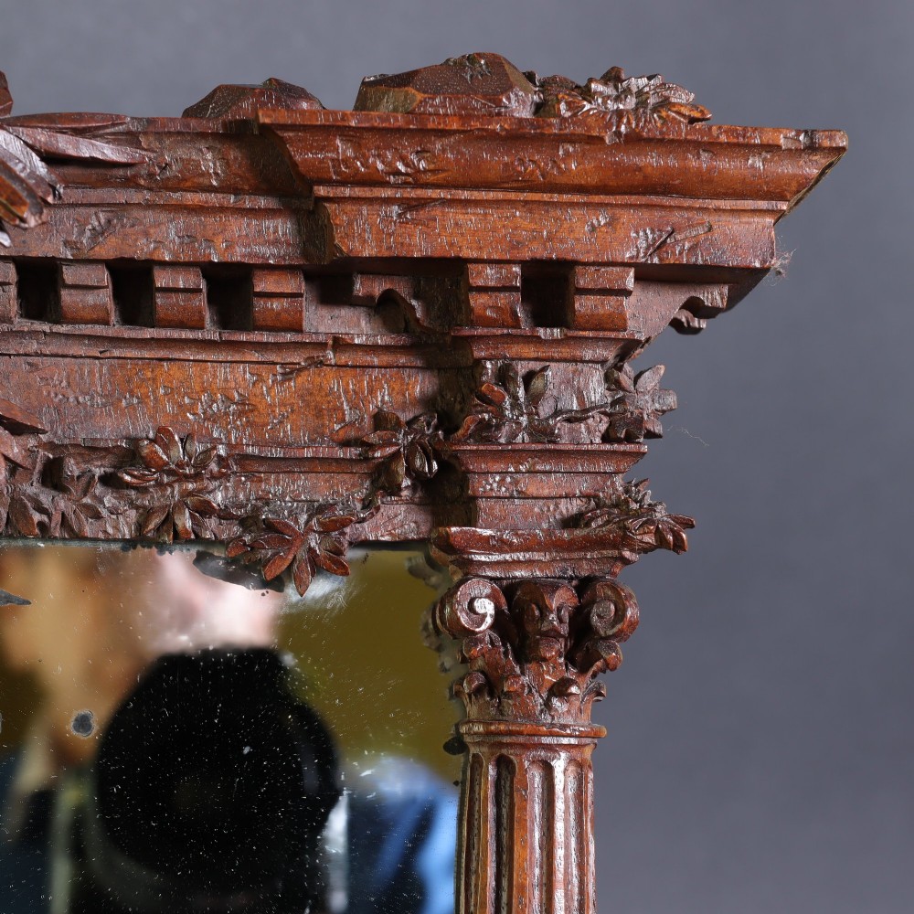 A late nineteenth-century Black Forest carved walnut table mirror featuring ornate architectural columns and botanical leaf carvings around the central rectangular mirror glass. View VIII