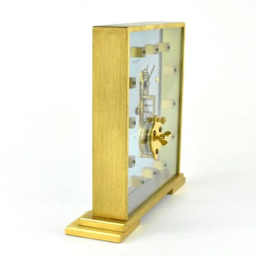 fig 2. A mid-century Jaeger-LeCoultre brass and glass square mantel clock featuring a visible internal skeleton movement and square brass hour markers.