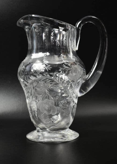 fig 1. A clear lead crystal drinking set comprising a large floral-engraved pitcher alongside three matching wine and tumbler glasses.