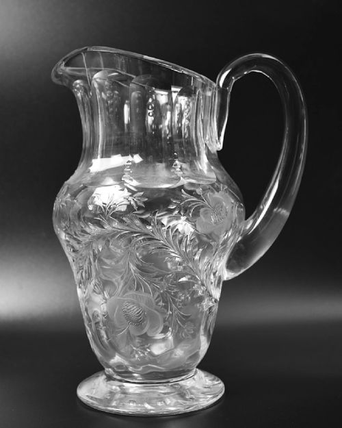 fig 2. A clear lead crystal drinking set comprising a large floral-engraved pitcher alongside three matching wine and tumbler glasses.