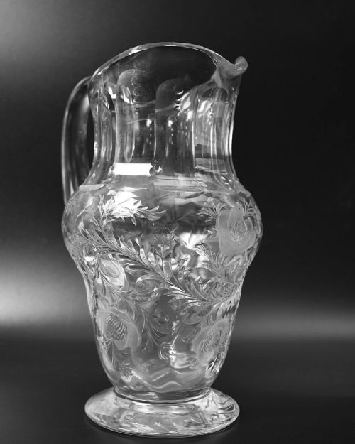 fig 3. A clear lead crystal drinking set comprising a large floral-engraved pitcher alongside three matching wine and tumbler glasses.