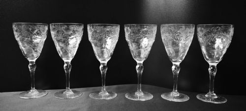 fig 4. A clear lead crystal drinking set comprising a large floral-engraved pitcher alongside three matching wine and tumbler glasses.