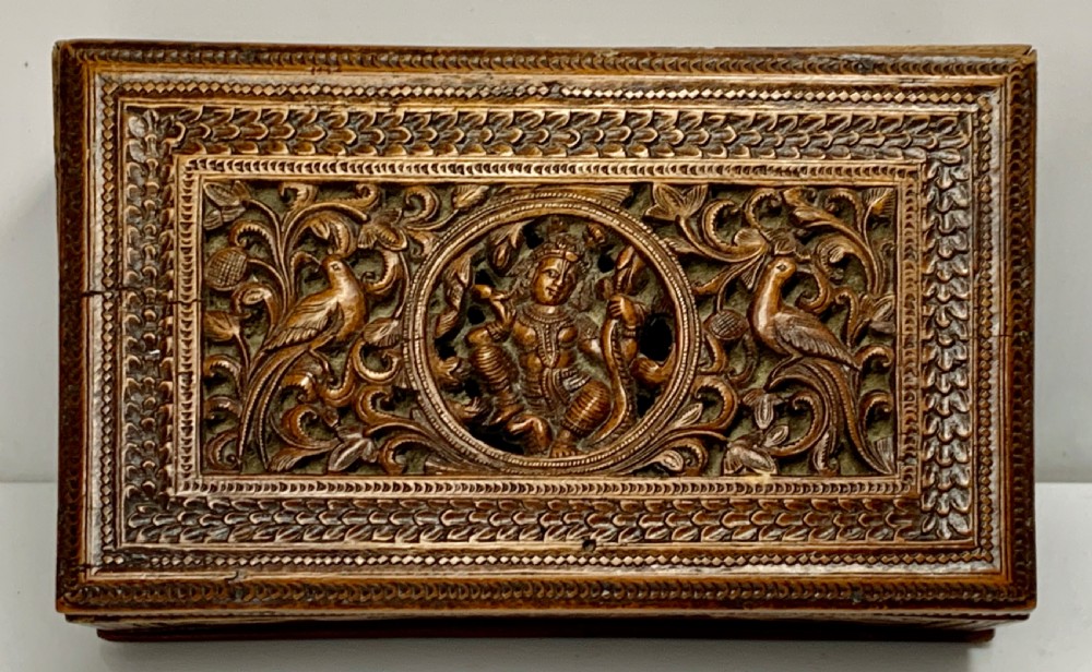 A nineteenth-century rectangular wooden box featuring intricate high-relief carvings of birds, foliage, and a central circular motif across the lid and sides. View IV
