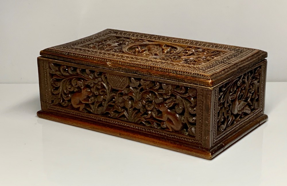 A nineteenth-century rectangular wooden box featuring intricate high-relief carvings of birds, foliage, and a central circular motif across the lid and sides. View VI