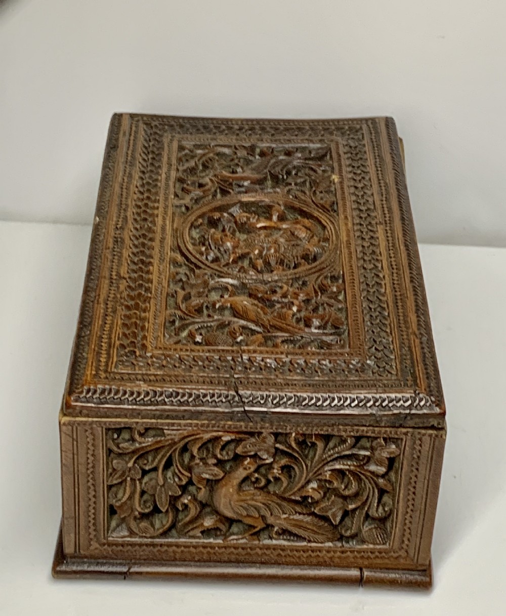 A nineteenth-century rectangular wooden box featuring intricate high-relief carvings of birds, foliage, and a central circular motif across the lid and sides. View VII