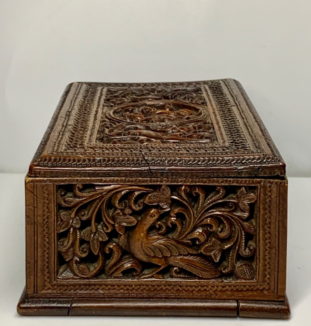 A nineteenth-century rectangular wooden box featuring intricate high-relief carvings of birds, foliage, and a central circular motif across the lid and sides. View VIII