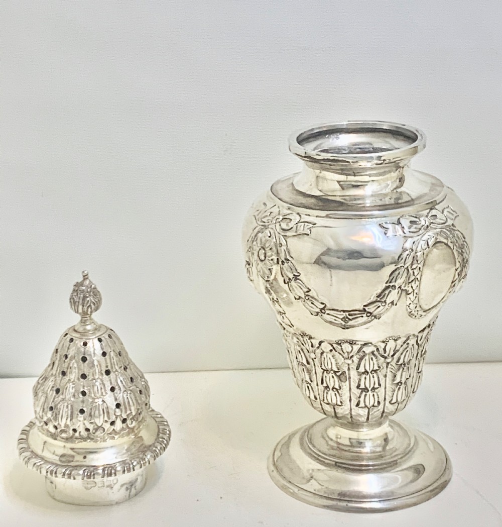 An urn-shaped Edwardian sterling silver sugar caster featuring chased ribbon bow swags and a pierced removable dome lid. View VI