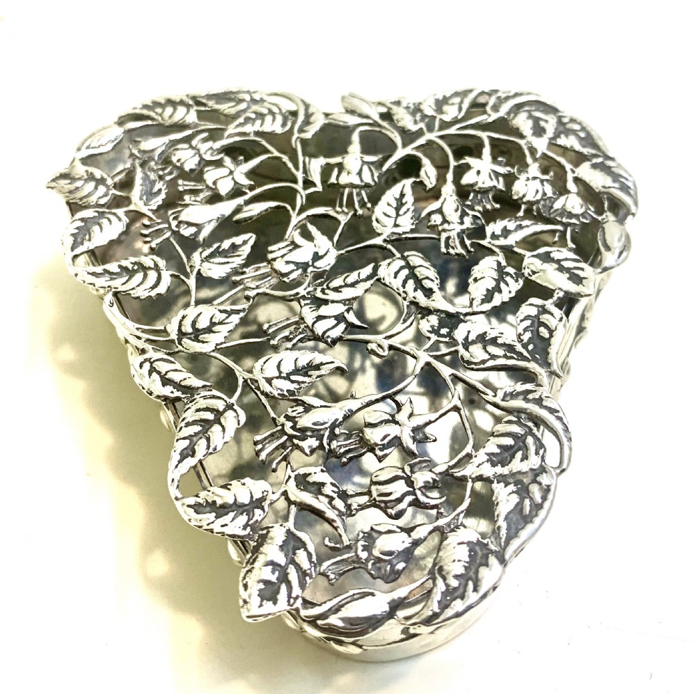 An Edwardian heart-shaped sterling silver trinket box featuring intricate pierced foliate openwork on the lid. View IV