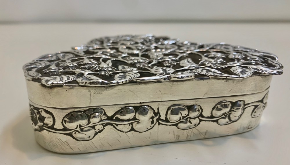 An Edwardian heart-shaped sterling silver trinket box featuring intricate pierced foliate openwork on the lid. View VI