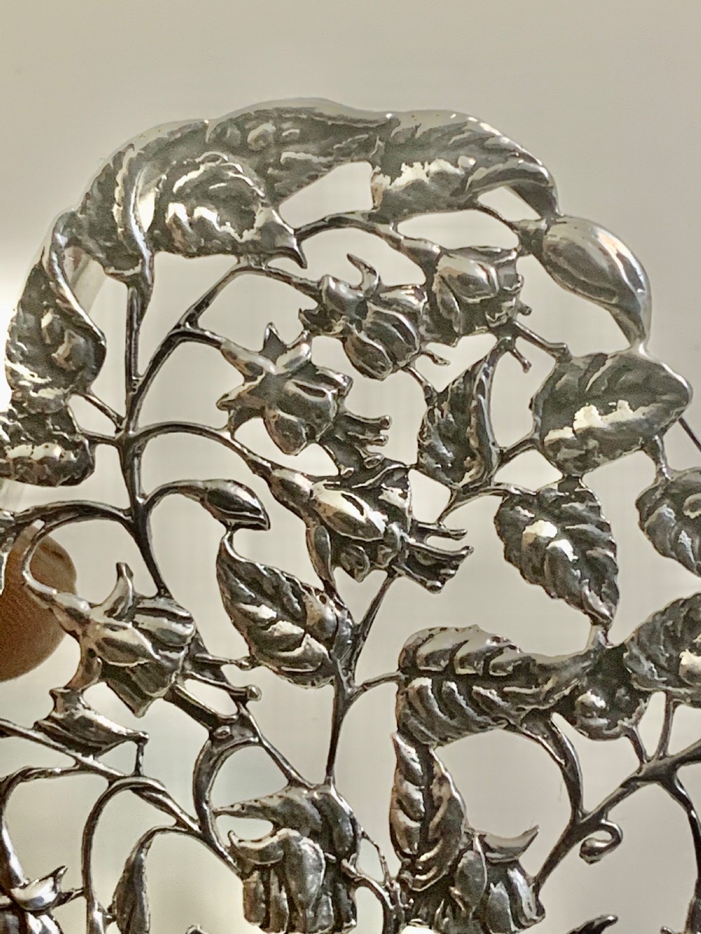 An Edwardian heart-shaped sterling silver trinket box featuring intricate pierced foliate openwork on the lid. View X