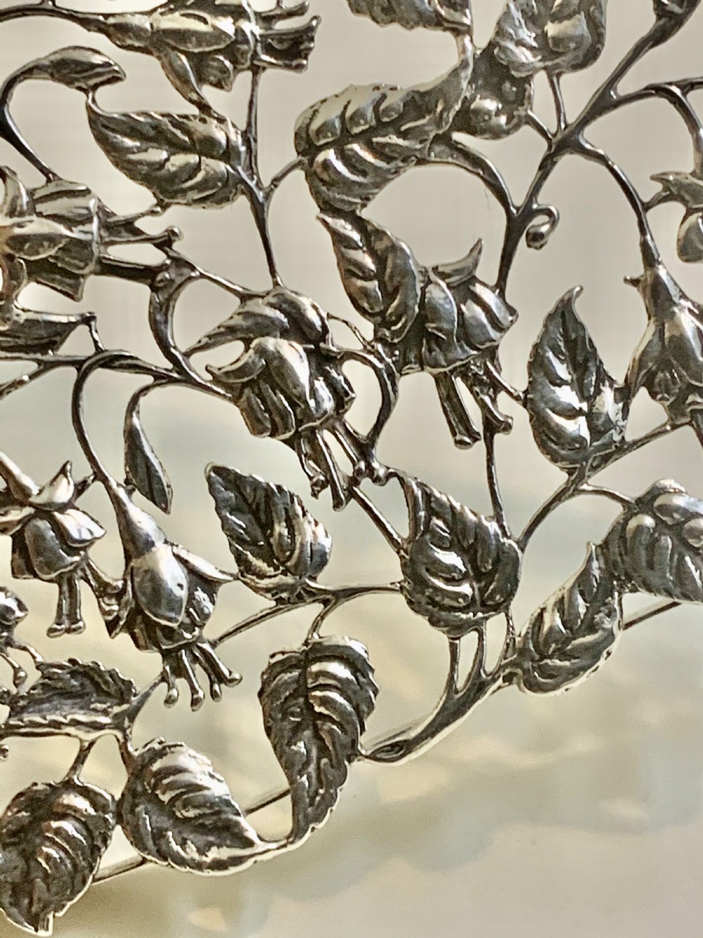 An Edwardian heart-shaped sterling silver trinket box featuring intricate pierced foliate openwork on the lid. View XI