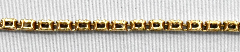 A mid-century 14ct yellow gold flexible line bracelet set with round diamonds, featuring a box clasp and safety chain. View IV