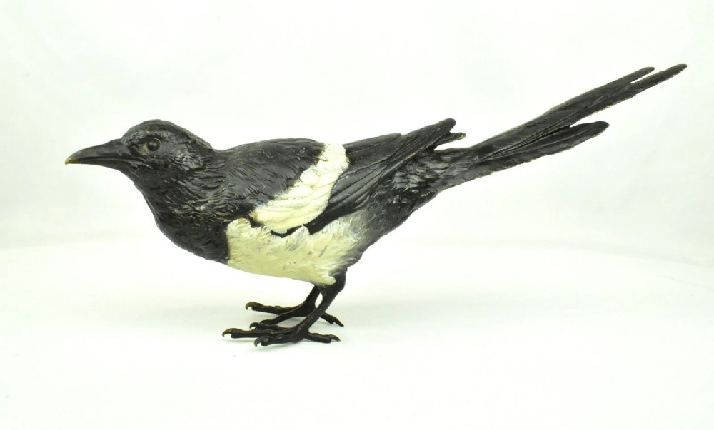 An antique cold-painted bronze figure depicting a magpie with detailed black and white polychrome finish.