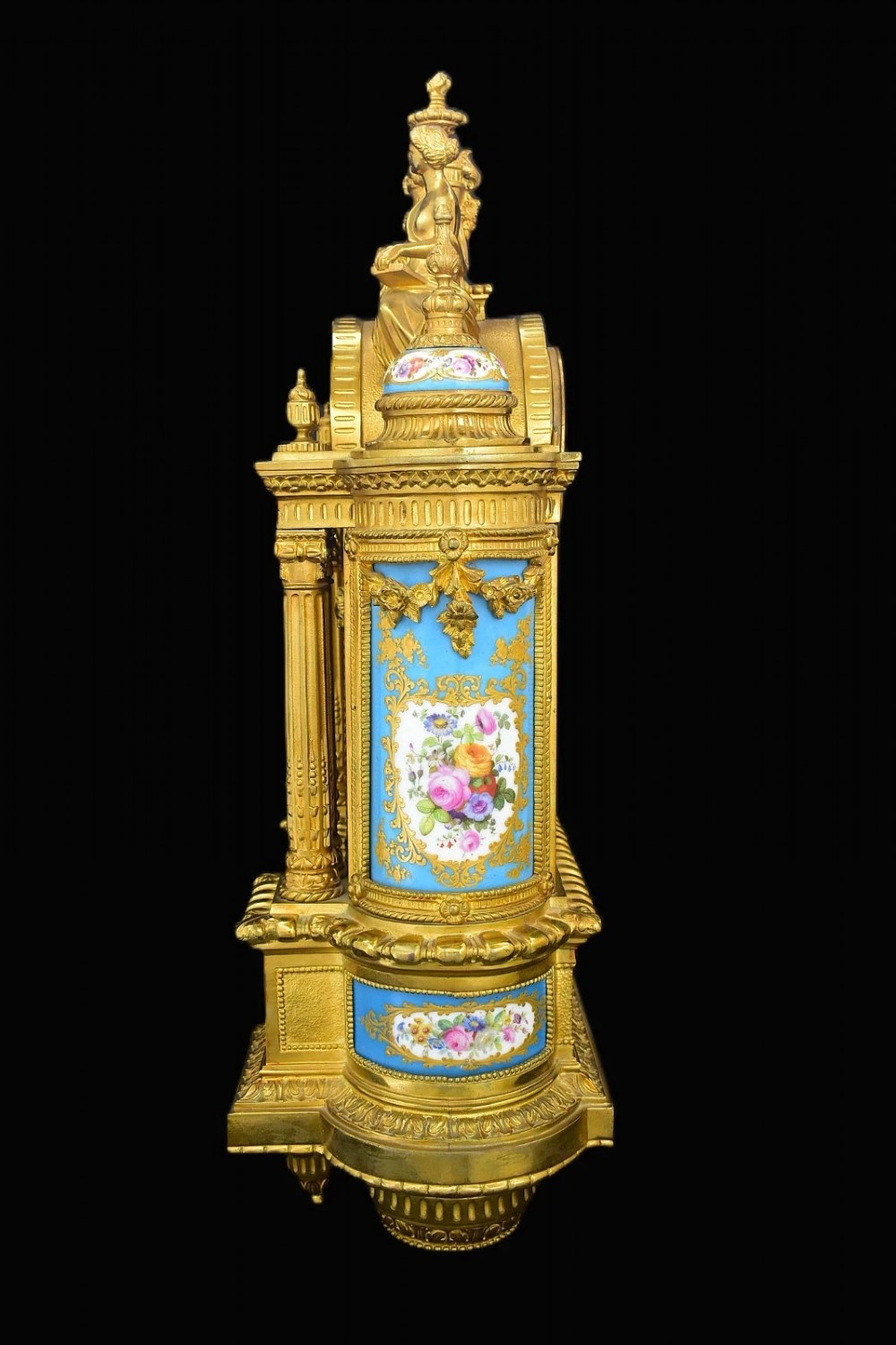 A French Napoleon III period ormolu mantel clock featuring hand-painted blue porcelain panels, classical female figures, twin fluted columns, and an enamelled dial. View V