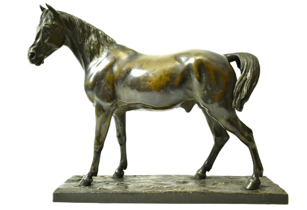 A dark brown patinated bronze sculpture of a standing horse positioned on an integral rectangular base.