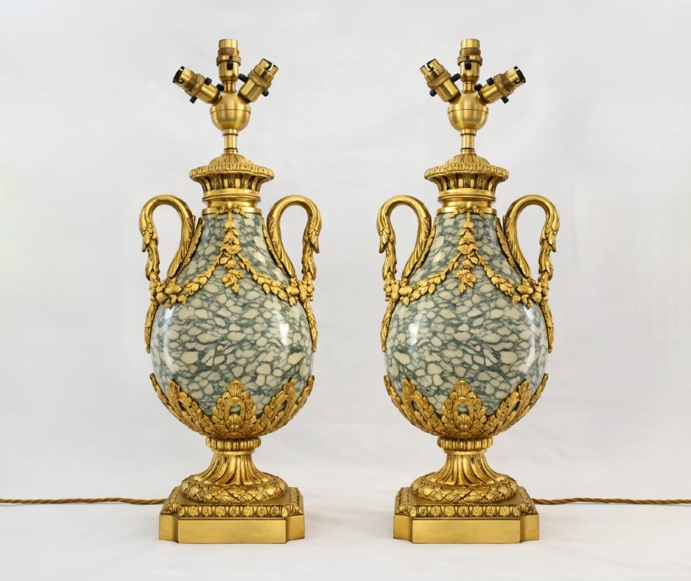 A pair of nineteenth-century French Louis XVI style cassolette table lamps crafted from green mottled marble with gilt bronze mounts and handles.