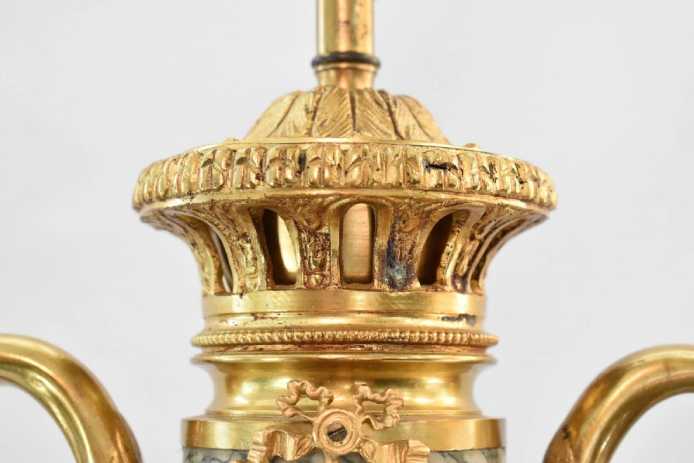 A pair of nineteenth-century French Louis XVI style cassolette table lamps crafted from green mottled marble with gilt bronze mounts and handles. View X