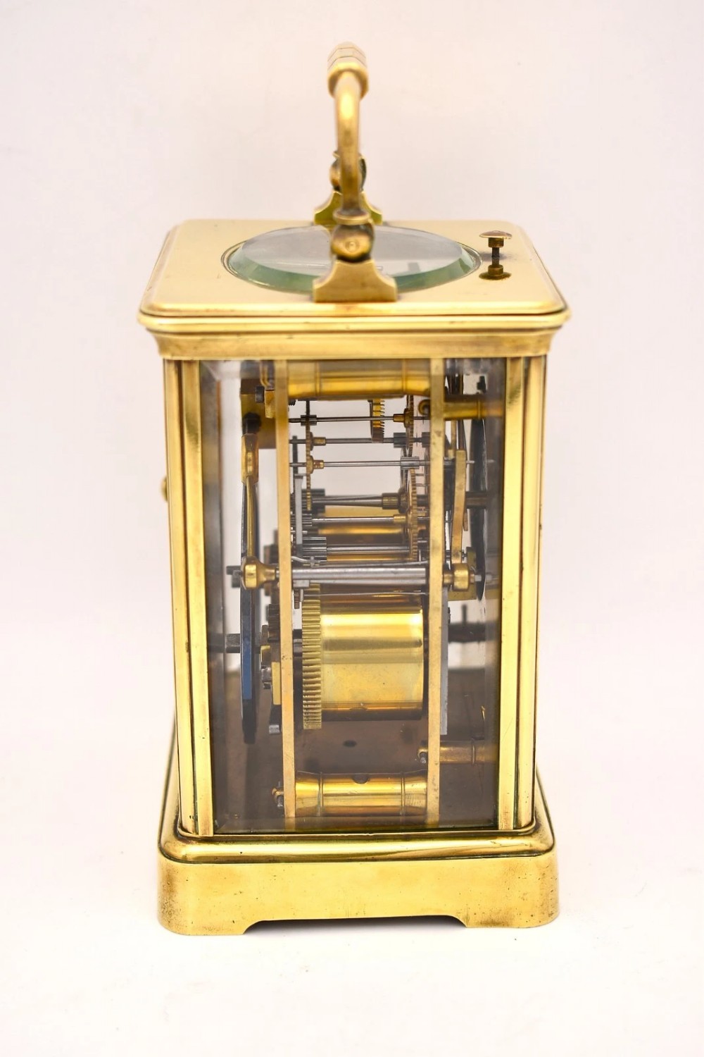 A Victorian brass carriage clock featuring a top handle, glass side panels, and a white enamel dial with Roman numerals. View II