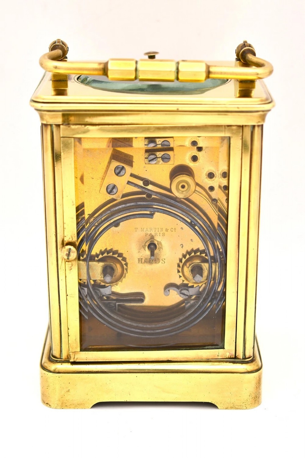 A Victorian brass carriage clock featuring a top handle, glass side panels, and a white enamel dial with Roman numerals. View III