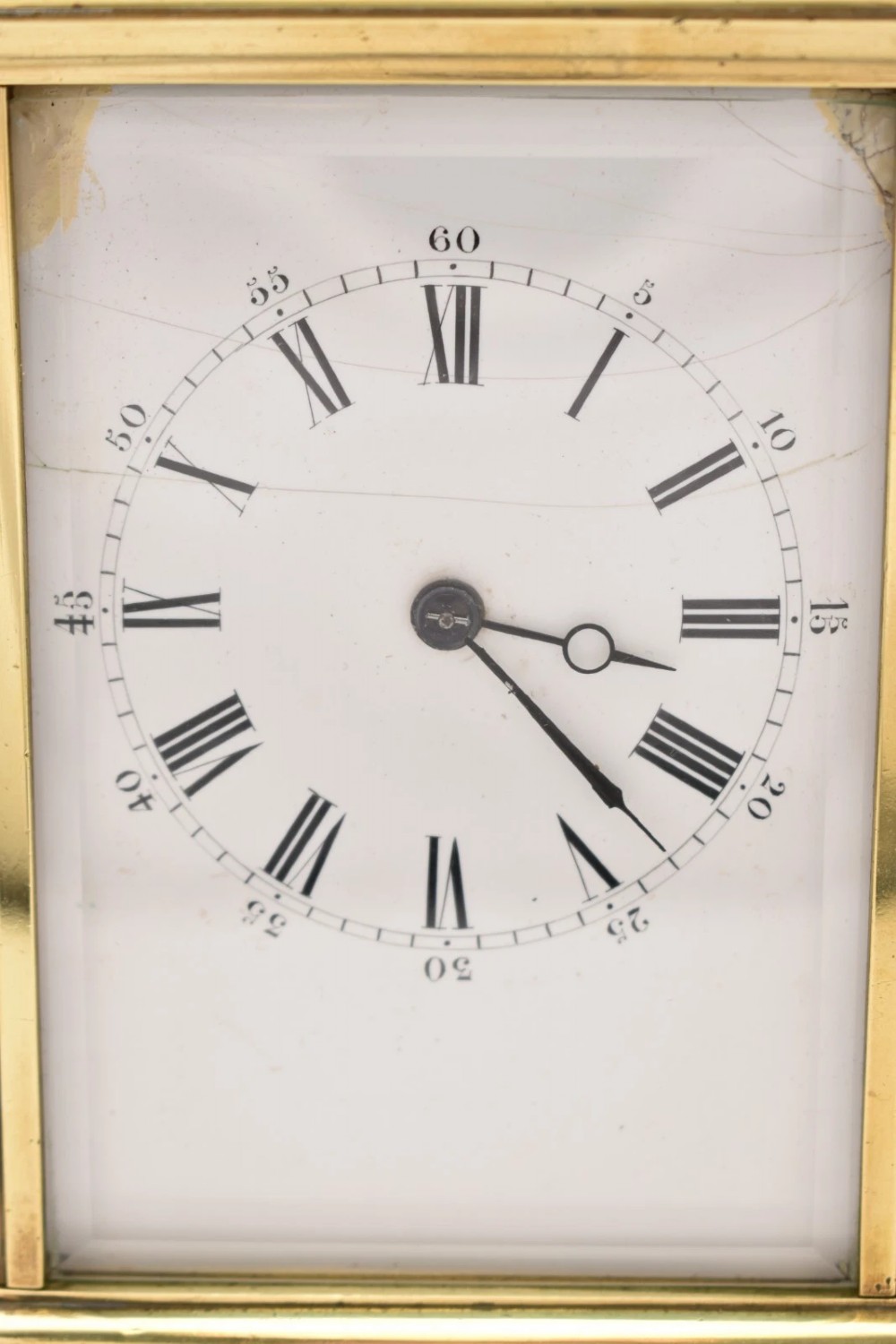 A Victorian brass carriage clock featuring a top handle, glass side panels, and a white enamel dial with Roman numerals. View VII