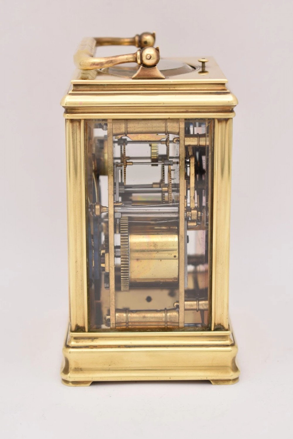 A late nineteenth-century French brass gorge case carriage clock featuring a white enamel dial with Roman numerals and a hinged top carrying handle. View II