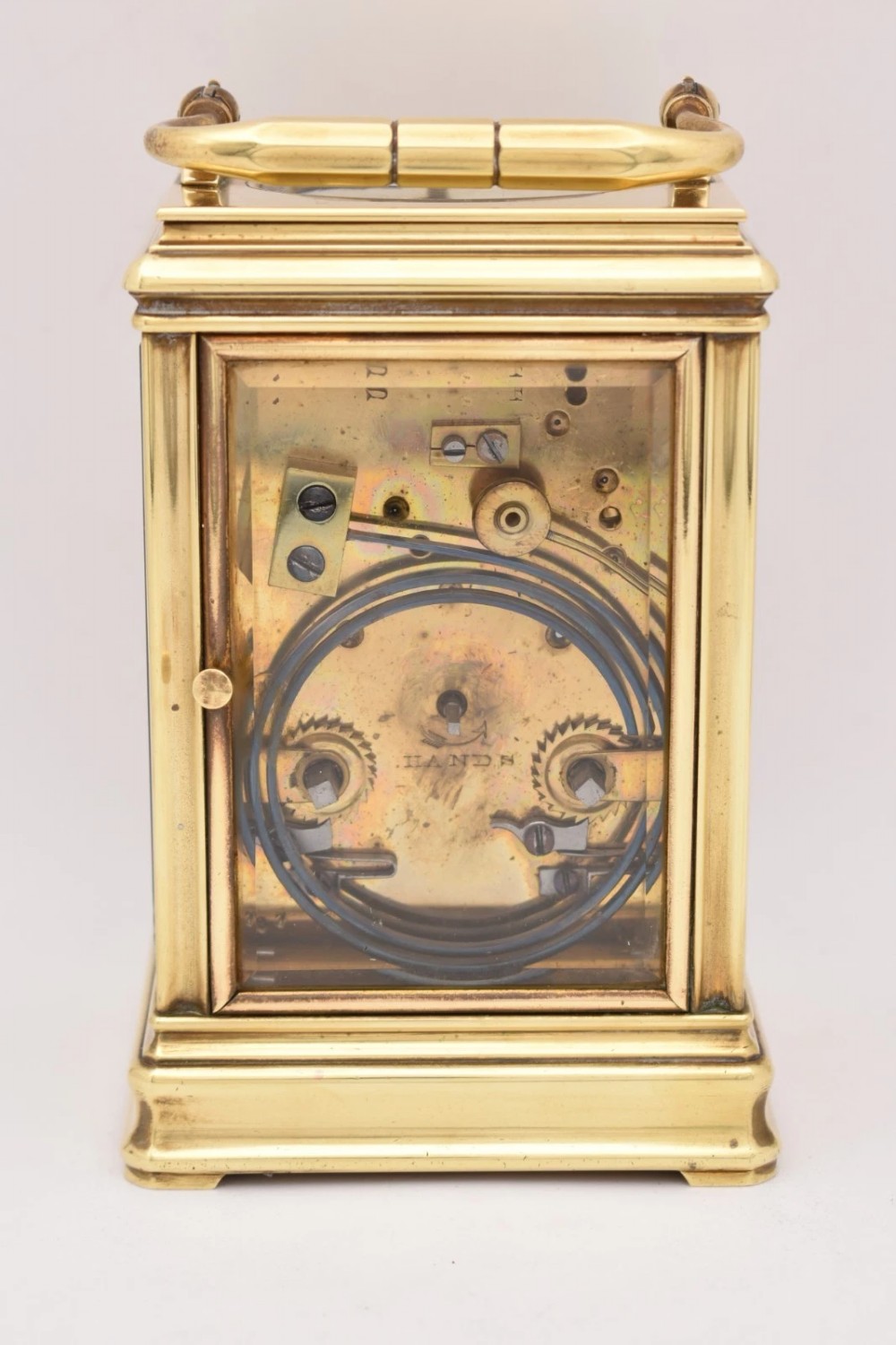 A late nineteenth-century French brass gorge case carriage clock featuring a white enamel dial with Roman numerals and a hinged top carrying handle. View III