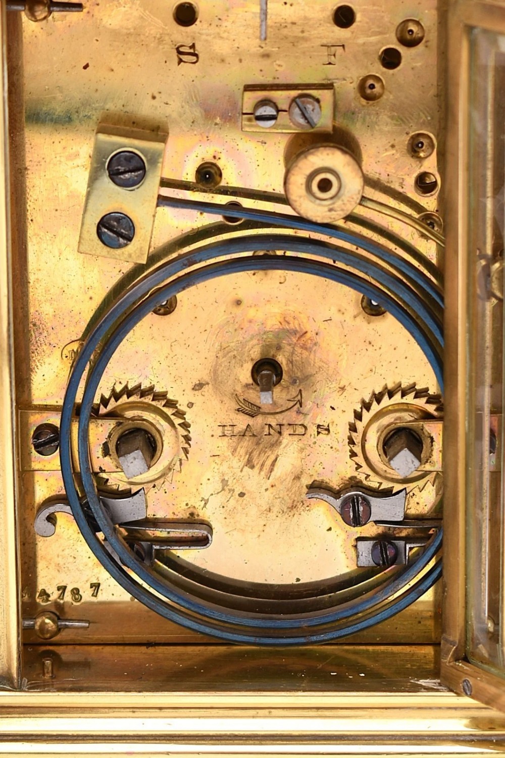 A late nineteenth-century French brass gorge case carriage clock featuring a white enamel dial with Roman numerals and a hinged top carrying handle. View IV