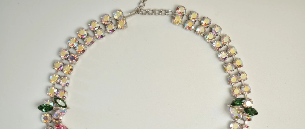 A 1950s Christian Dior costume jewellery parure set featuring a necklace, brooch, and clip-on earrings with pink, green, and aurora borealis crystal floral clusters. View IV