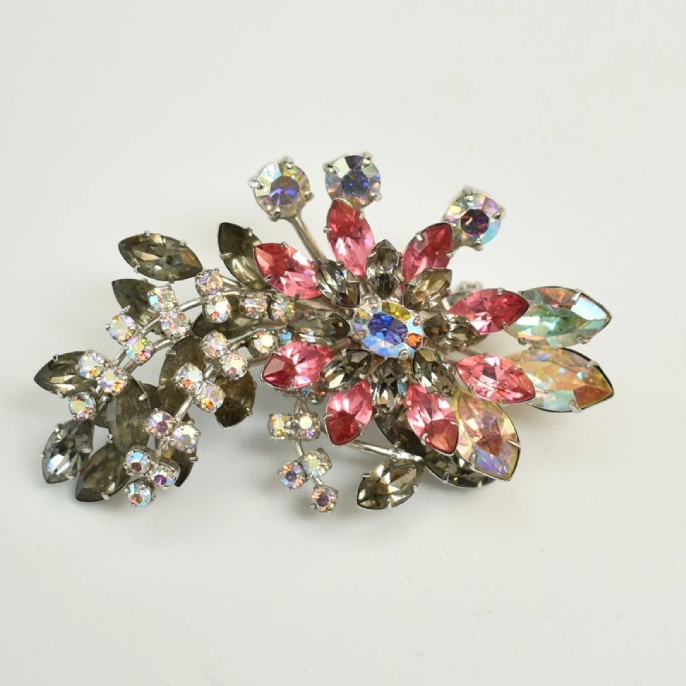 A 1950s Christian Dior costume jewellery parure set featuring a necklace, brooch, and clip-on earrings with pink, green, and aurora borealis crystal floral clusters. View VI