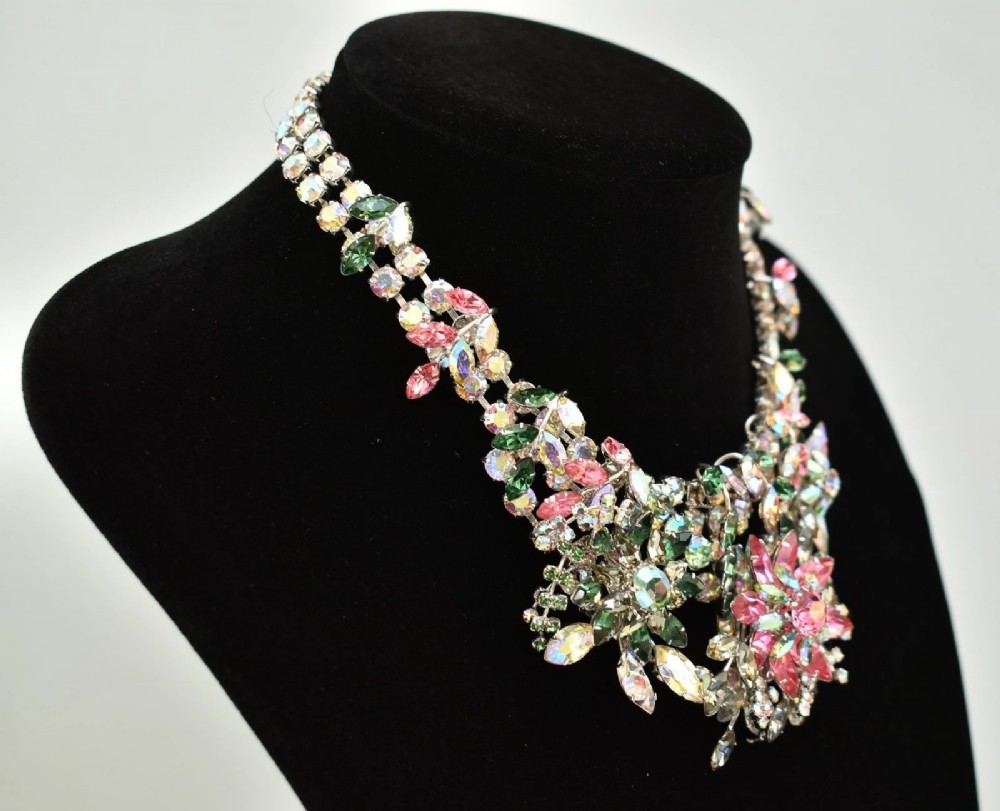 A 1950s Christian Dior costume jewellery parure set featuring a necklace, brooch, and clip-on earrings with pink, green, and aurora borealis crystal floral clusters. View XV