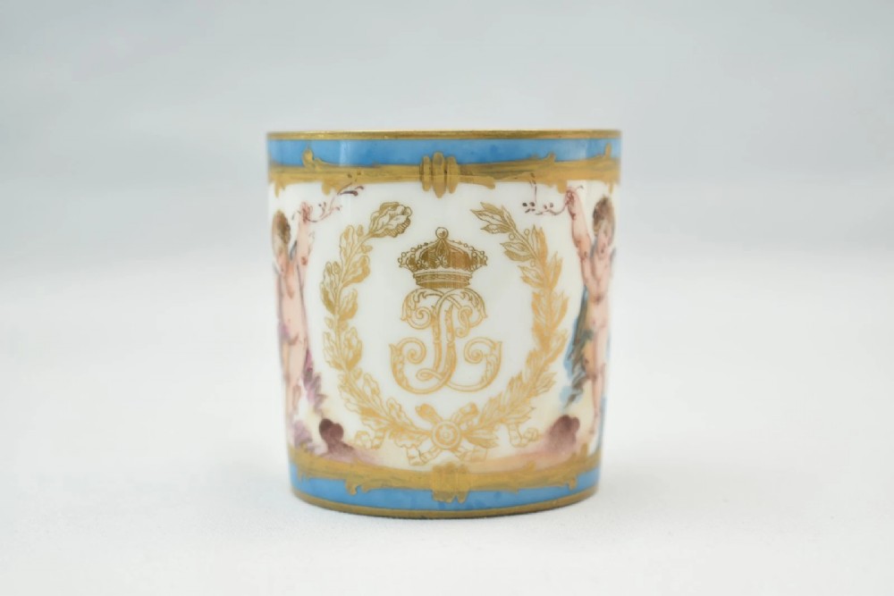 A six-piece set of white and sky-blue French porcelain demitasse cups and saucers decorated with gilded royal monograms, cherubs, and leaf borders. View III
