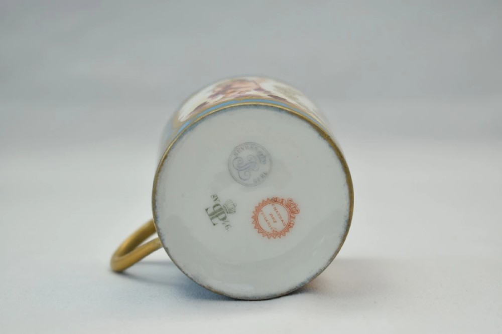 A six-piece set of white and sky-blue French porcelain demitasse cups and saucers decorated with gilded royal monograms, cherubs, and leaf borders. View VII