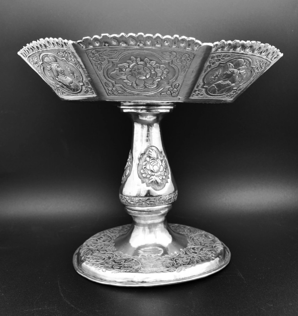 An octagonal antique silver repousse tazza featuring a central raised portrait medallion, intricate chased foliate side panels, and a pierced scalloped border. View IV