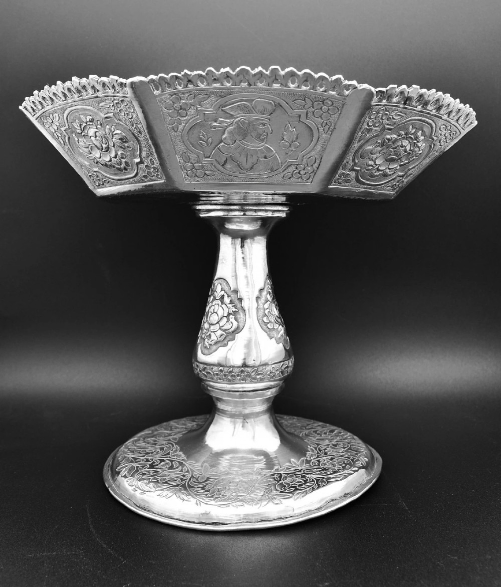 An octagonal antique silver repousse tazza featuring a central raised portrait medallion, intricate chased foliate side panels, and a pierced scalloped border. View V