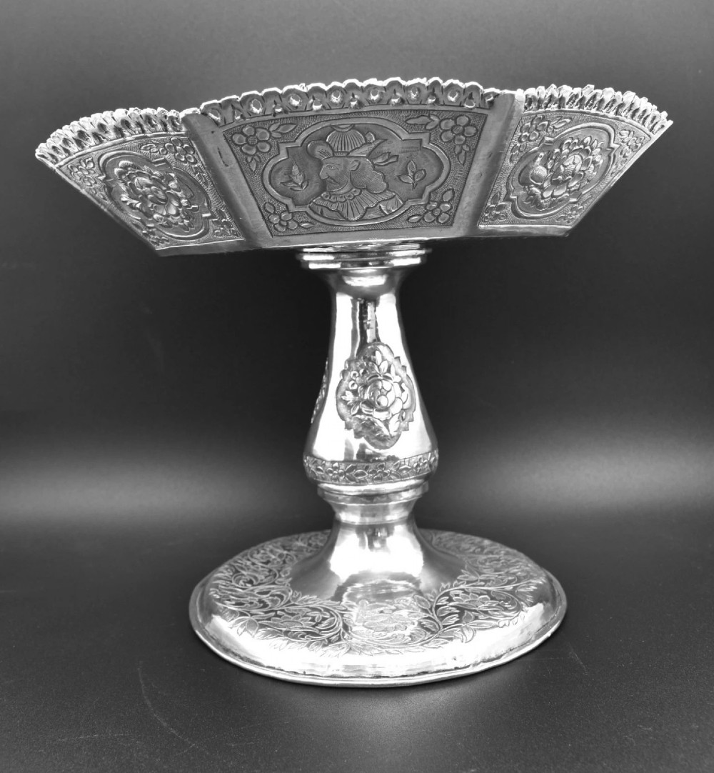 An octagonal antique silver repousse tazza featuring a central raised portrait medallion, intricate chased foliate side panels, and a pierced scalloped border. View IX