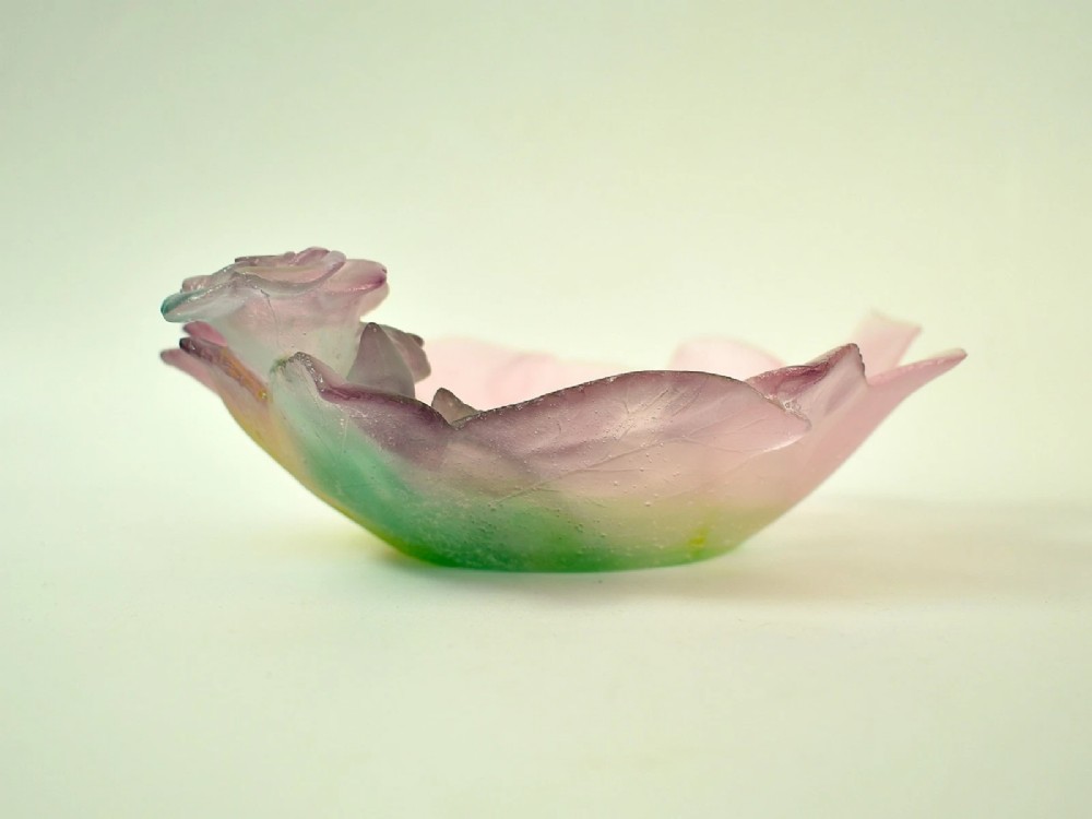 A Daum France pate de verre crystal rose bowl shaped like a pink blossom with green leaves, displayed alongside its original presentation box. View VII