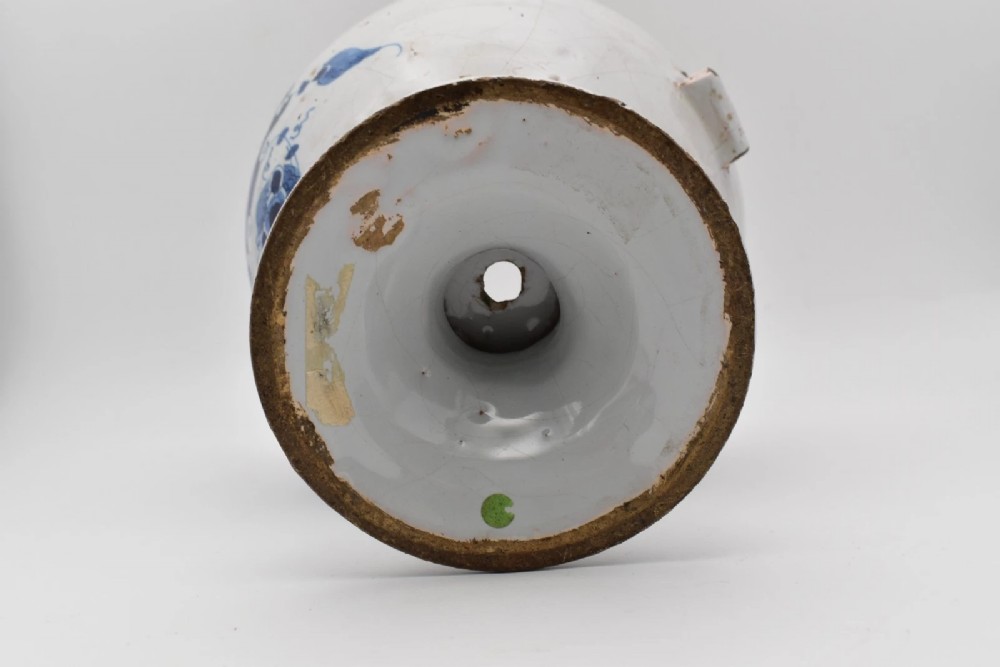 An 18th-century English delftware apothecary wet drug jar decorated in cobalt blue and white with a pouring spout, footed base, cherub motif, and the inscription S: BALSAM. View VI