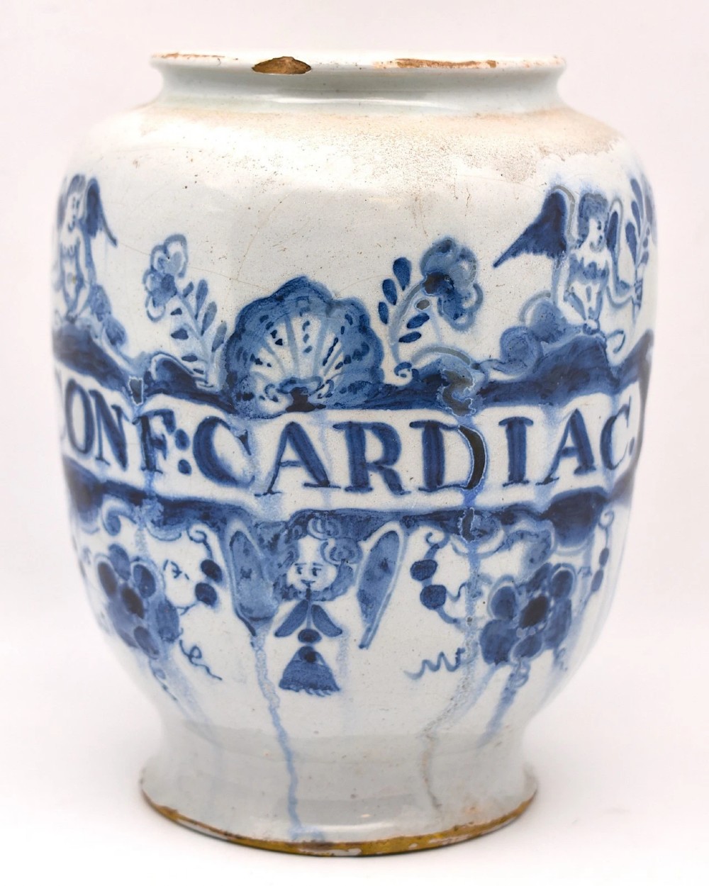 An 18th-century tin-glazed earthenware delftware drug jar featuring hand-painted cobalt blue cartouche decoration with cherubs and the Latin inscription CONF CARDIAC.