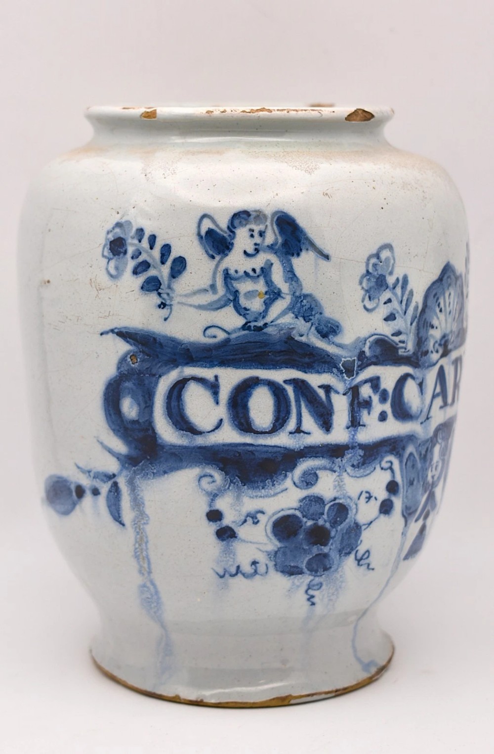 An 18th-century tin-glazed earthenware delftware drug jar featuring hand-painted cobalt blue cartouche decoration with cherubs and the Latin inscription CONF CARDIAC. View II
