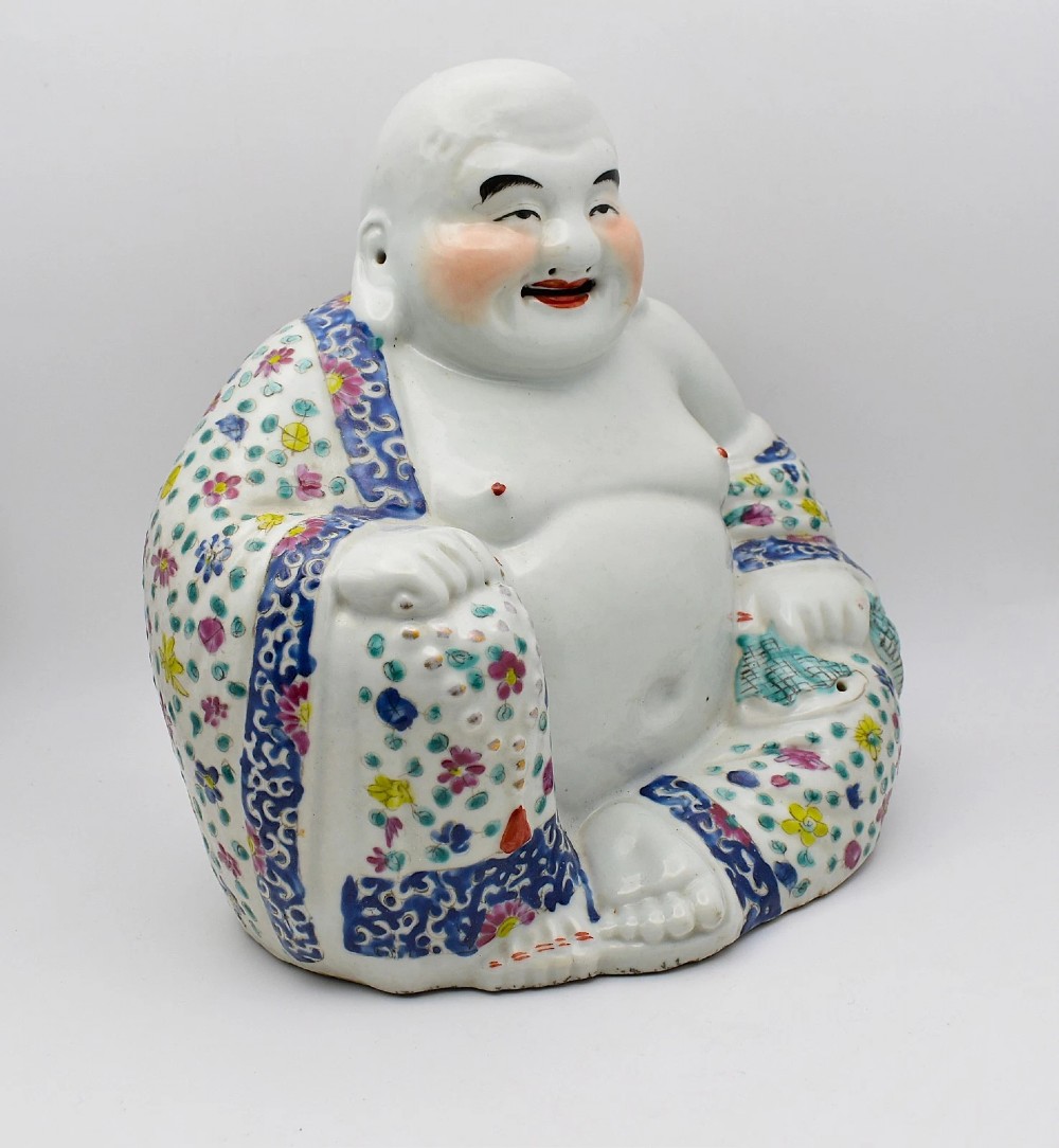 A seated twentieth-century Chinese famille rose porcelain figure of a laughing Budai draped in a floral enamelled robe. View V