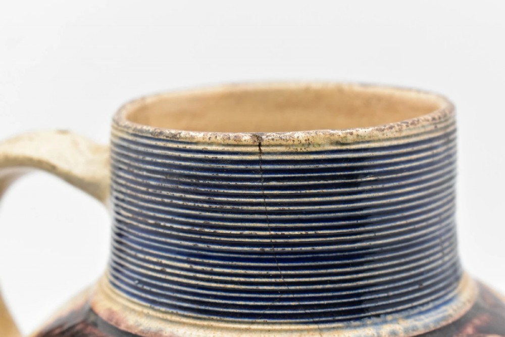 A seventeenth-century salt-glazed Westerwald stoneware jug decorated with cobalt blue and manganese violet glazes, featuring a central medallion with a royal portrait profile. View VIII