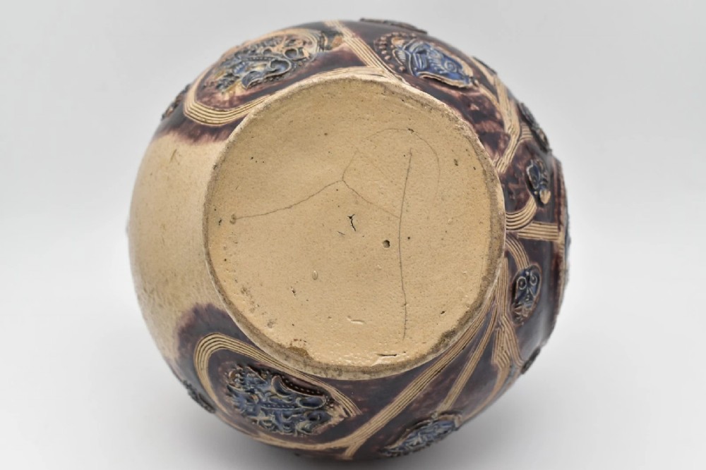A seventeenth-century salt-glazed Westerwald stoneware jug decorated with cobalt blue and manganese violet glazes, featuring a central medallion with a royal portrait profile. View XI