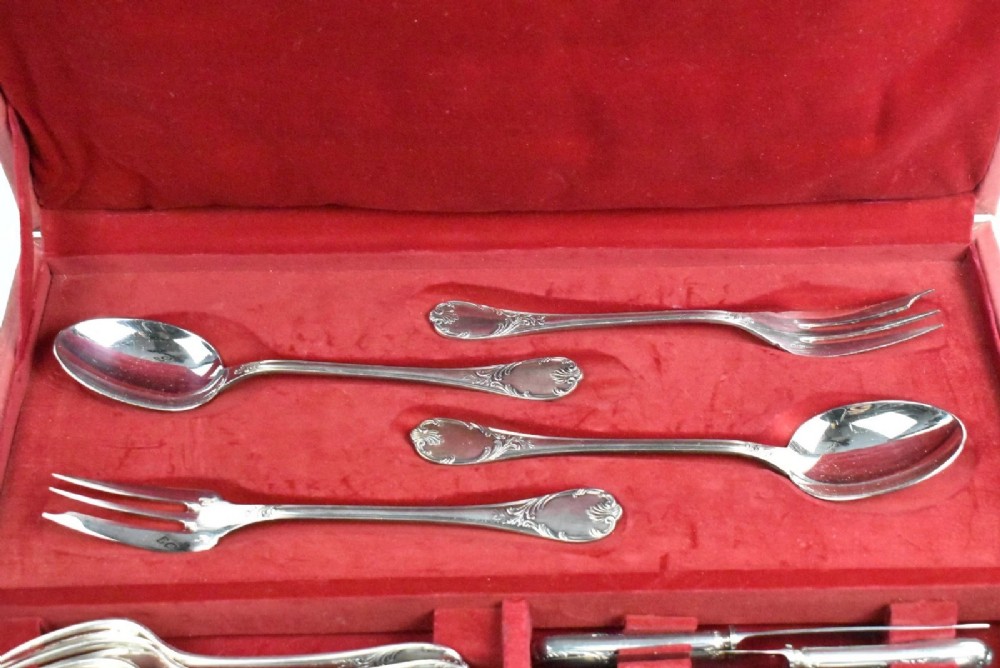 A 52-piece silver-plated cutlery set arranged neatly inside a red velvet-lined presentation case. View II