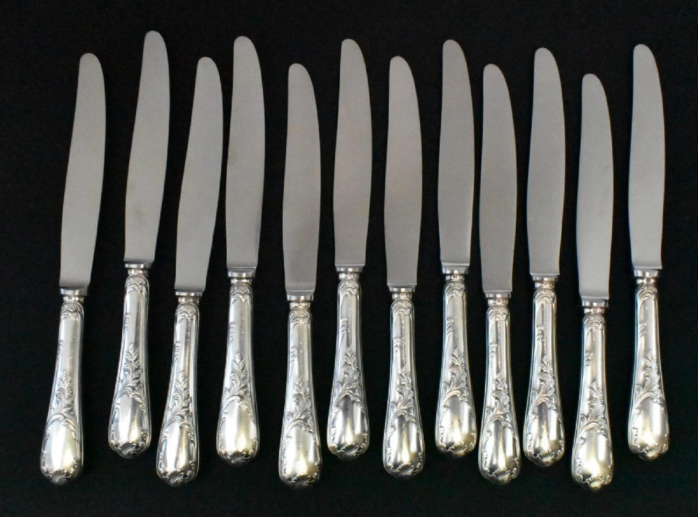 A 52-piece silver-plated cutlery set arranged neatly inside a red velvet-lined presentation case. View X