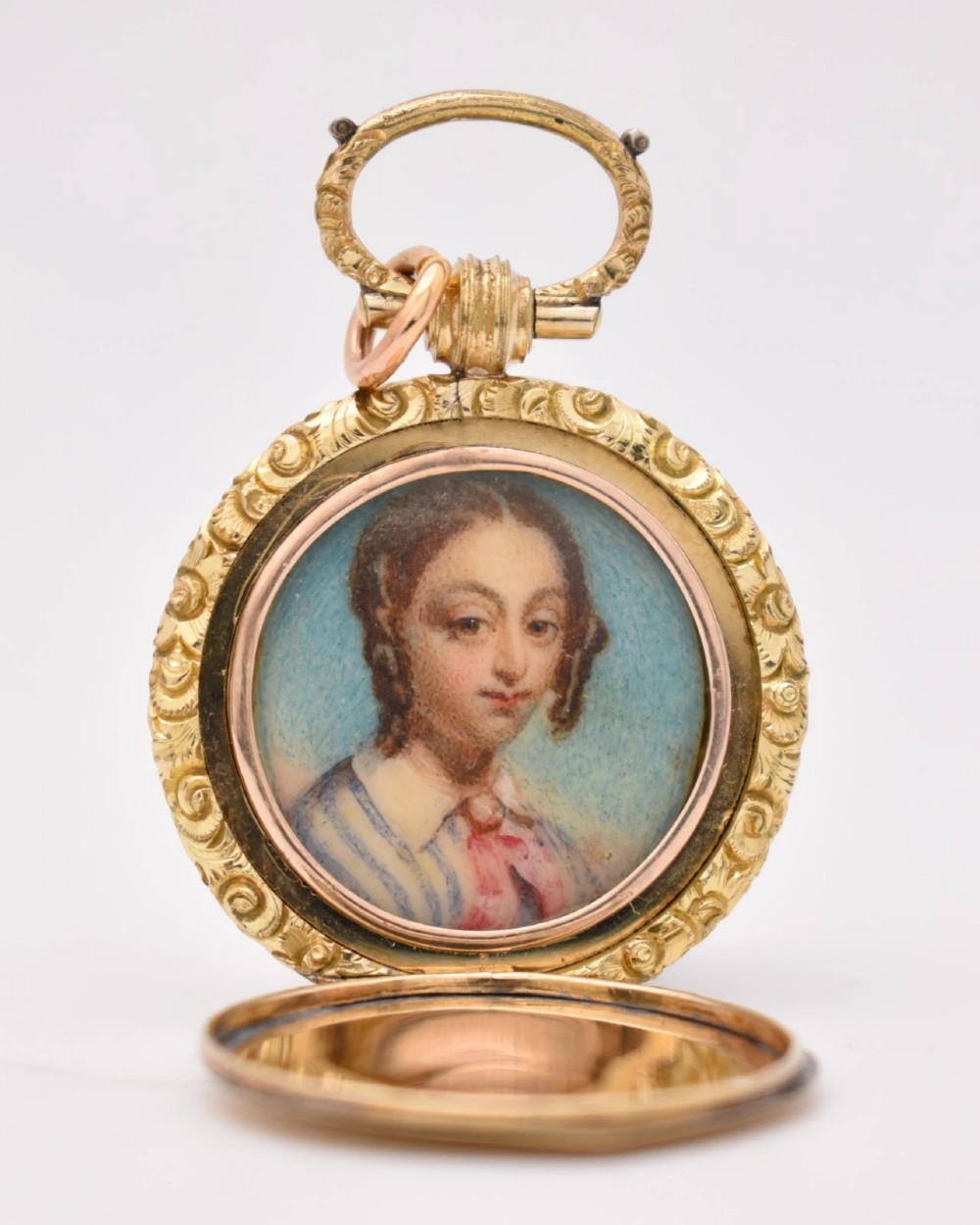 A circular gold locket pendant featuring a hand-painted portrait of a woman with dark hair against a light blue background.